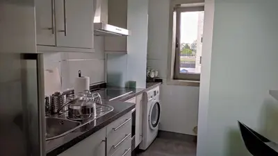 a kitchen with a sink and a washing machine at Wanderlust Bastiagueiro in Perillo