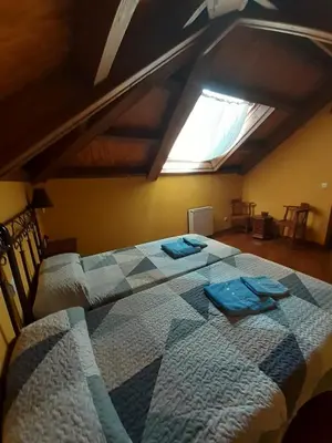 a bedroom with two beds in a attic at OSO3 in Pola de Somiedo