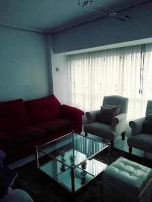 a living room with a red couch and a glass coffee table at OSO3 in Pola de Somiedo