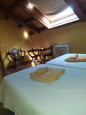 a bedroom with two beds and a table with a window at OSO4 in Pola de Somiedo
