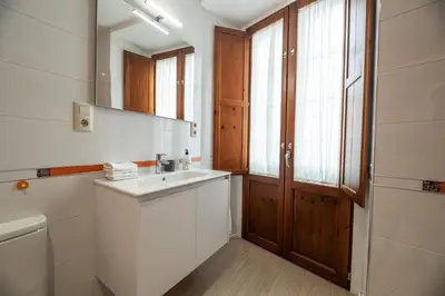 a white bathroom with a sink and a window at EREA apartamentos turísticos in Monforte de Lemos