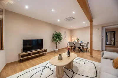 a living room with a couch and a tv and a table at SACRA apartamentos turísticos in Monforte de Lemos