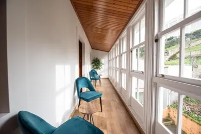 a hallway with blue chairs and windows at SACRA apartamentos turísticos in Monforte de Lemos