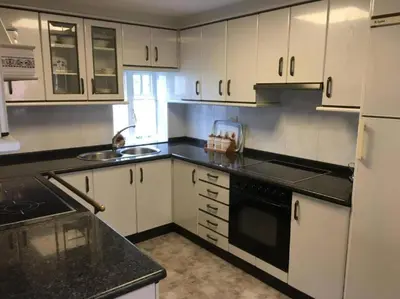 a kitchen with white cabinets and a black counter top at Casa Eudosia, Tenorio in Barro