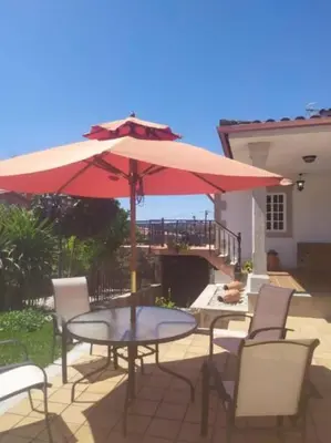 a table and chairs with an umbrella on a patio at Casa Eudosia, Tenorio in Barro
