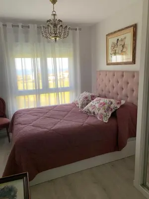 a bedroom with a purple bed with a chandelier at DUNAS DE LLAS in Foz