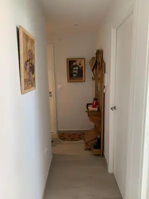 a hallway with a white room with a door and a staircase at DUNAS DE LLAS in Foz