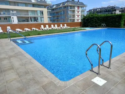 a large swimming pool with white chairs next to a building at DUNAS DE LLAS in Foz