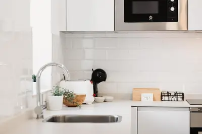 a kitchen counter with a sink and a microwave at Apartamentos Ares Rentals in Ares