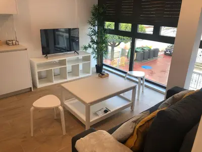 a living room with a couch and a table and a tv at Apartamentos Ares Rentals in Ares