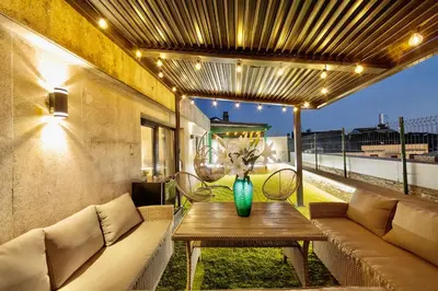 a patio with a couch and a table with a vase on it at Lucus Skyline & Terrace by Lugo Collection in Lugo