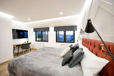 a bedroom with a bed and a desk and windows at Lucus Skyline & Terrace by Lugo Collection in Lugo