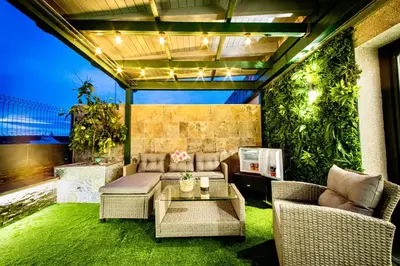 a patio with a couch and a table and some plants at Lucus Skyline & Terrace by Lugo Collection in Lugo