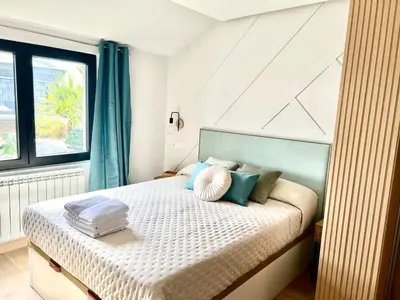 a bedroom with a bed with a blue headboard at Lucus Skyline & Terrace by Lugo Collection in Lugo
