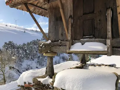 a wooden cabin with snow on the ground at Ca Manín in Tineo