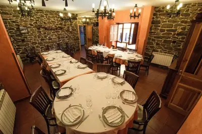 a room with tables and chairs in a restaurant at Hotel Rural La Bolera in Robles de Laciana