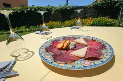a plate of food on a table with wine glasses at Hotel Rural La Bolera in Robles de Laciana