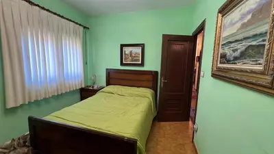 a bedroom with a bed and a painting on the wall at Casa Camiño do Eume in A Coruña