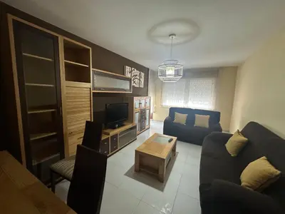 a living room with a couch and a tv at HOME GV35 By Oktheway in Sarria