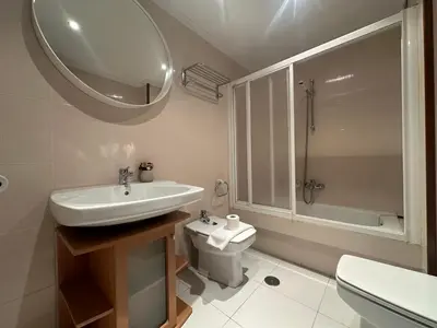 a bathroom with a sink and a toilet and a mirror at HOME GV35 By Oktheway in Sarria