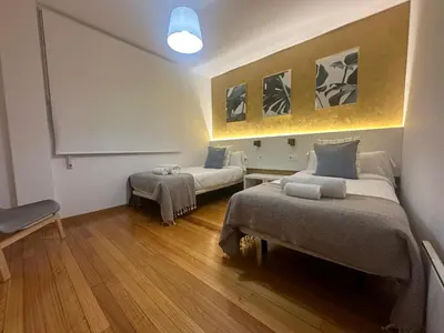 a hotel room with two beds and a table at HOME GV35 By Oktheway in Sarria