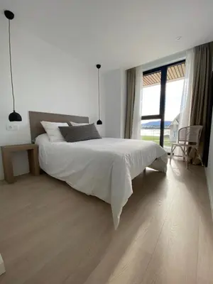 a white bedroom with a bed and a large window at APARTAMENTO A ESTRENAR en FOZ COFRADIA DELUXE in Foz