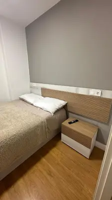 a small bedroom with a bed and a wooden floor at Apartamento Santiago in Santiago de Compostela