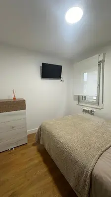a bedroom with a bed and a tv on the wall at Apartamento Santiago in Santiago de Compostela