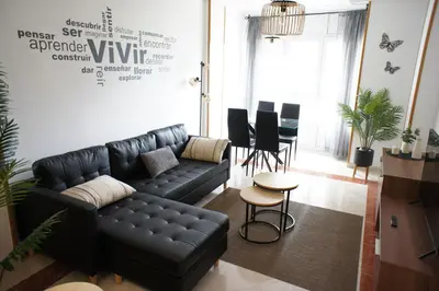 a living room with a black leather couch and a table at Alojamientos Viveiro - Playa de Covas I in Viveiro