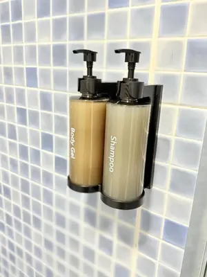 two bottles ofodorizers hanging on a bathroom wall at Piso Camino de Santiago in Sarria