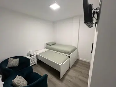 a small room with a bed and a chair at Piso Camino de Santiago in Sarria