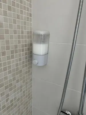a glass of milk in a shower in a bathroom at Piso Camino de Santiago in Sarria