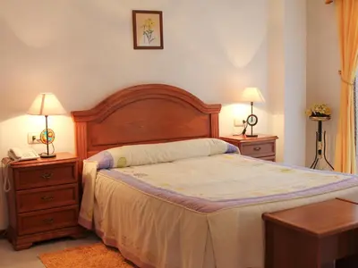 a bedroom with a bed and two nightstands and two lamps at Hotel Restaurante Xaneiro in Melide