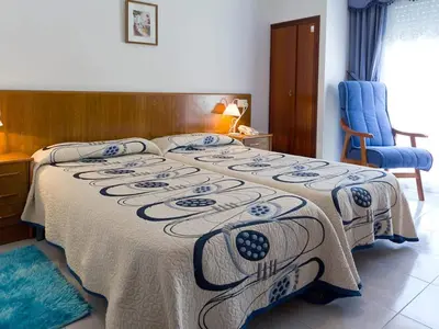 a bedroom with a bed with a blanket on it at Hotel Restaurante Xaneiro in Melide
