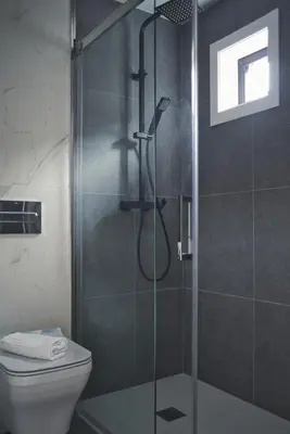 a bathroom with a glass shower with a toilet at HOTEL PORTOMARÍN STAR in Portomarin