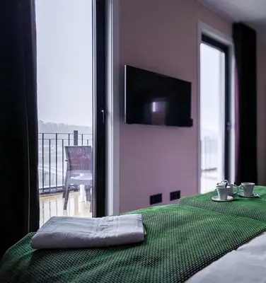 a room with a bed with a green table with a view at HOTEL PORTOMARÍN STAR in Portomarin