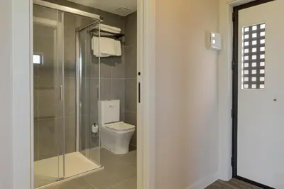 a bathroom with a toilet and a glass shower at HOTEL PORTOMARÍN STAR in Portomarin