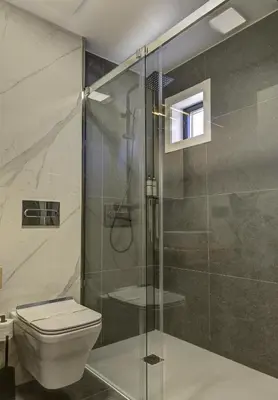 a bathroom with a toilet and a glass shower at HOTEL PORTOMARÍN STAR in Portomarin