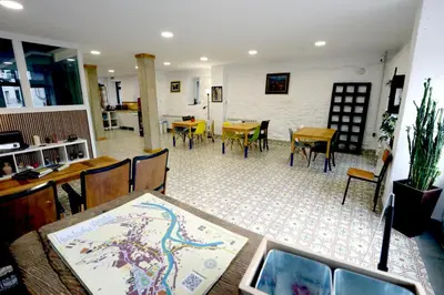 a dining room with tables and chairs and a room with tables and chairs at Hostel El Campano in Villafranca del Bierzo