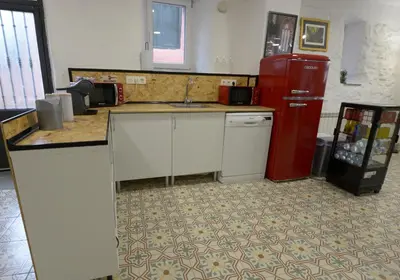 a kitchen with a red refrigerator and a sink at Hostel El Campano in Villafranca del Bierzo