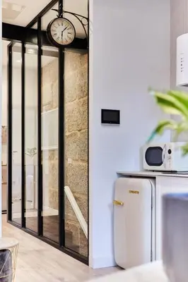 a kitchen with a clock on the wall and a refrigerator at Villa Julia in Ribadavia