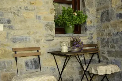 a table and two chairs in front of a stone wall at Casa Gloria in Moncó