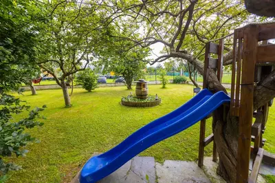 a blue slide in a park with a tree at Vivienda Vacacional Casa Fidel in Campas