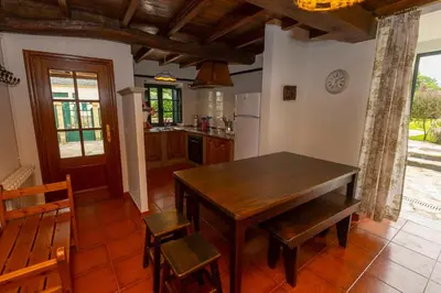 a kitchen with a wooden table and chairs at Vivienda Vacacional Casa Fidel in Campas