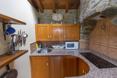 a kitchen with a sink and a clock on the wall at Vivienda Vacacional Casa Fidel in Campas