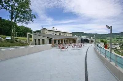 a building with tables and chairs on a patio at Hotel Parrilla el Zangano in Boal