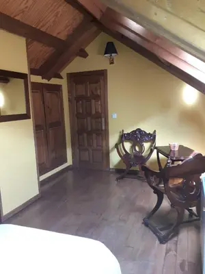 a living room with a table and a chair at CASA OSO 1 in Pola de Somiedo
