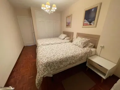 a small bedroom with a bed and a chandelier at SOL Y MAR in Vivero