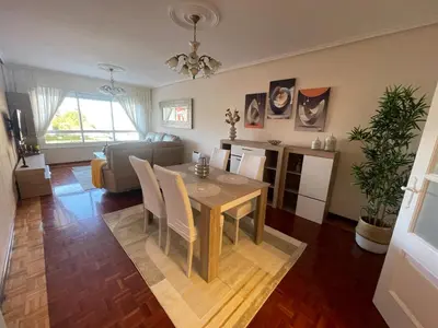 a dining room and living room with a table and chairs at SOL Y MAR in Vivero