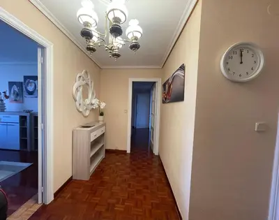 a room with a clock on the wall and a hallway at SOL Y MAR in Vivero